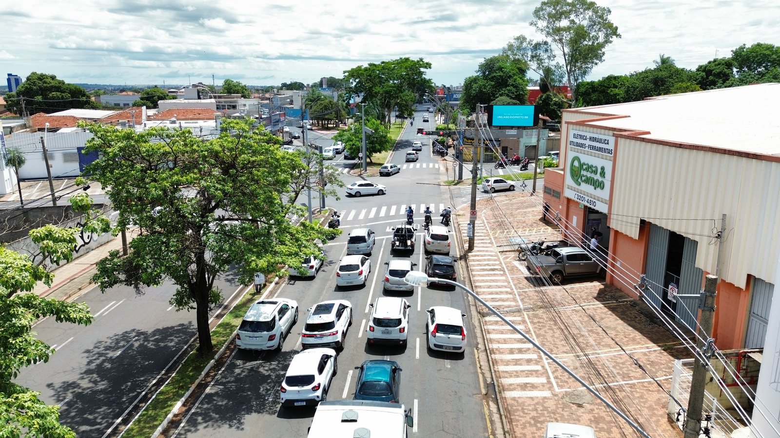 Painel de LED em cruzamento com comércio local em Rio Preto